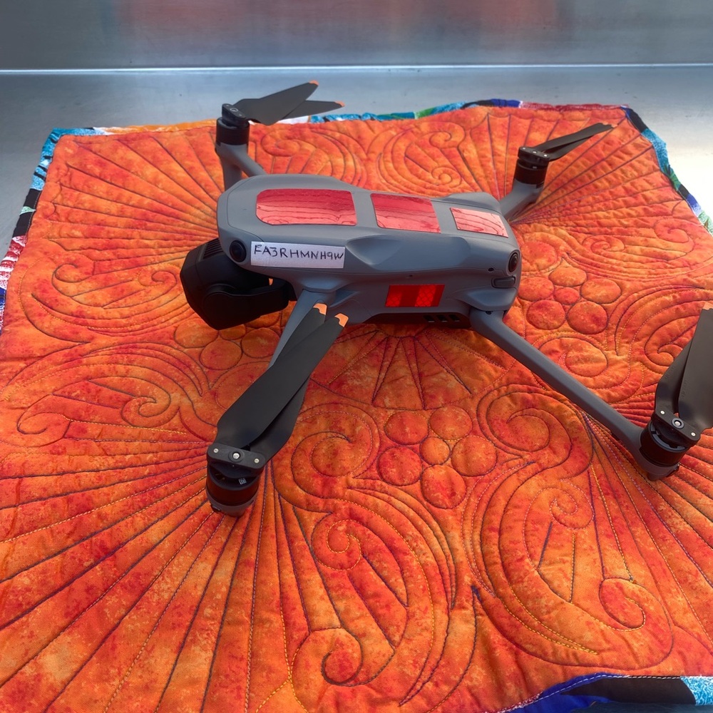 Quilted drone landing pad with weight